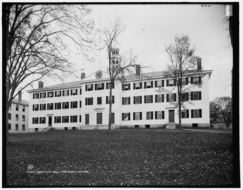 Dartmouth Hall, a long white colonial building with a cupola, seen across a lawn.