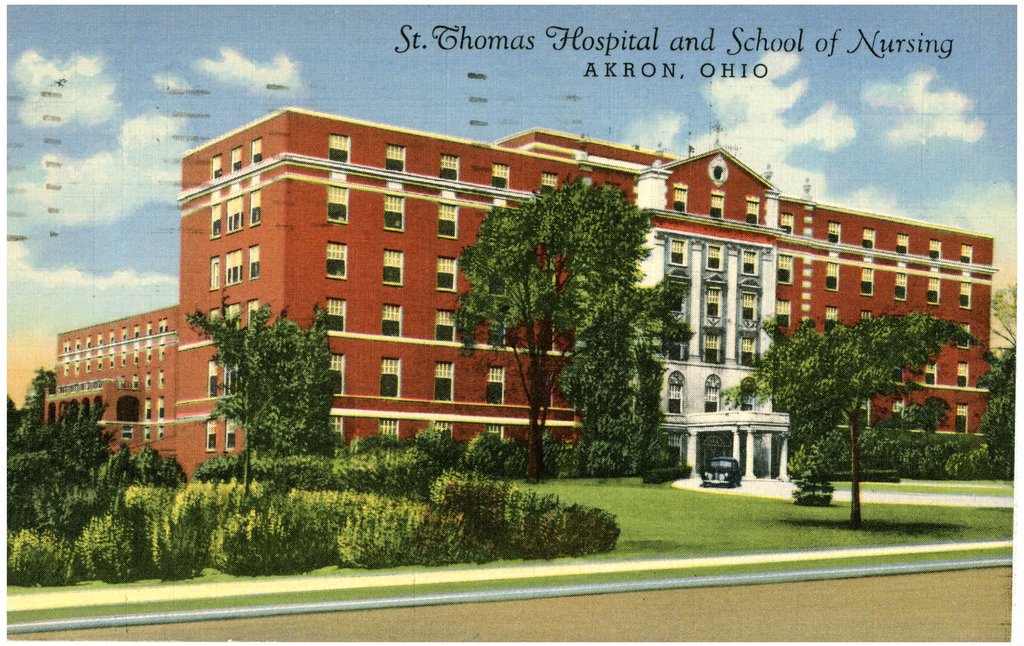 A color postcard of St. Thomas Hospital in Akron, a large brick building.