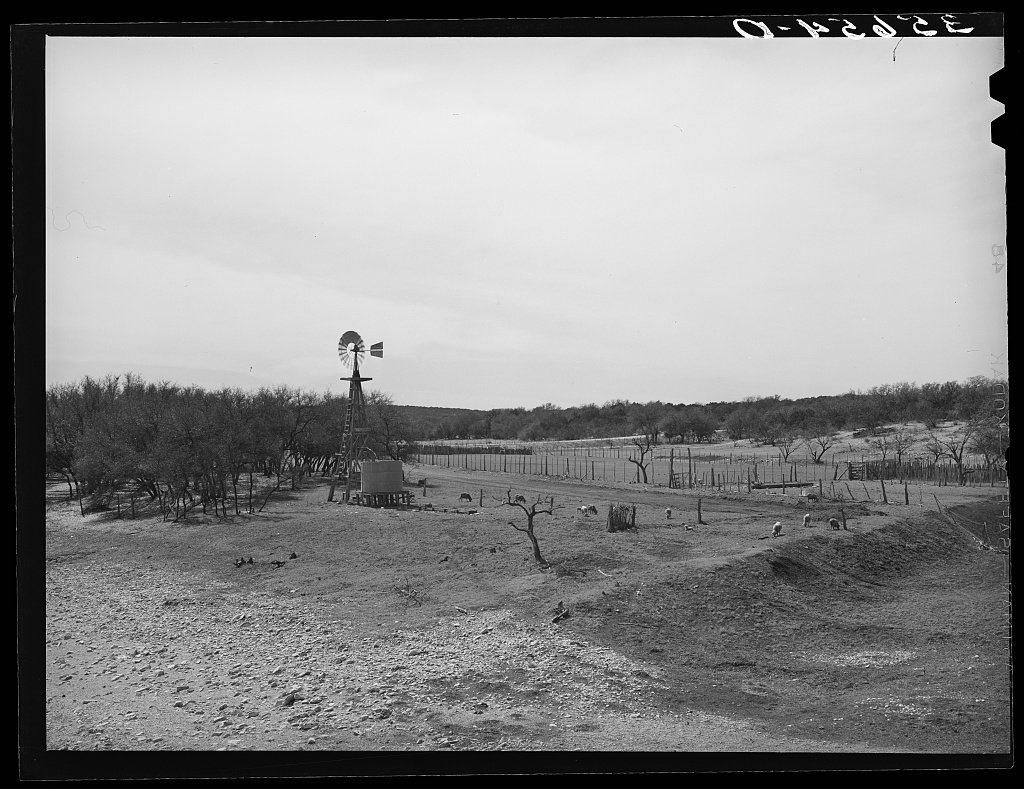 A windmill and a round stock-water tank on a West Texas ranch.